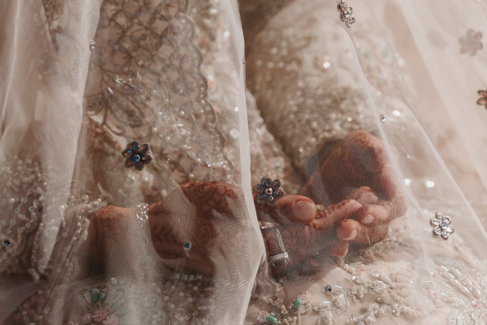 Wedding details through an embroidered veil