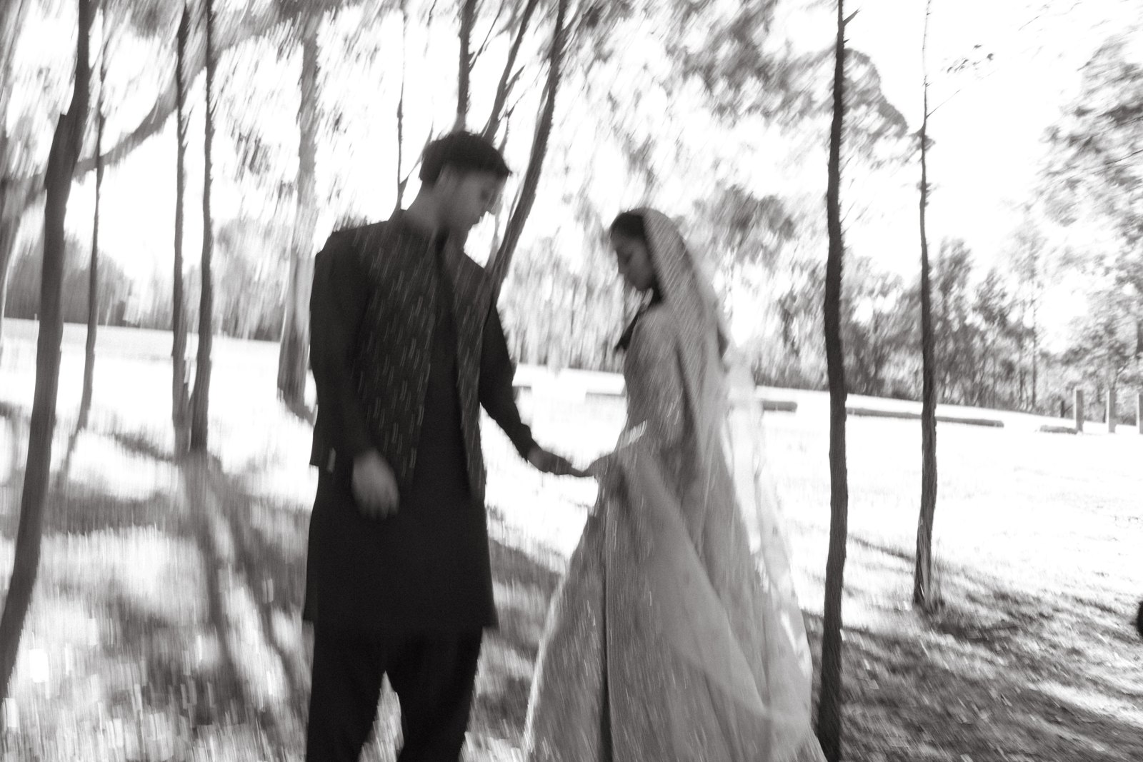 Newlyweds walking beneath the trees